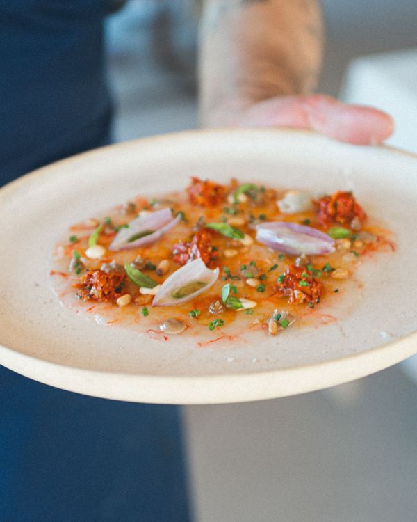 Plato de alta cocina con flores y cebolleta encurtida
