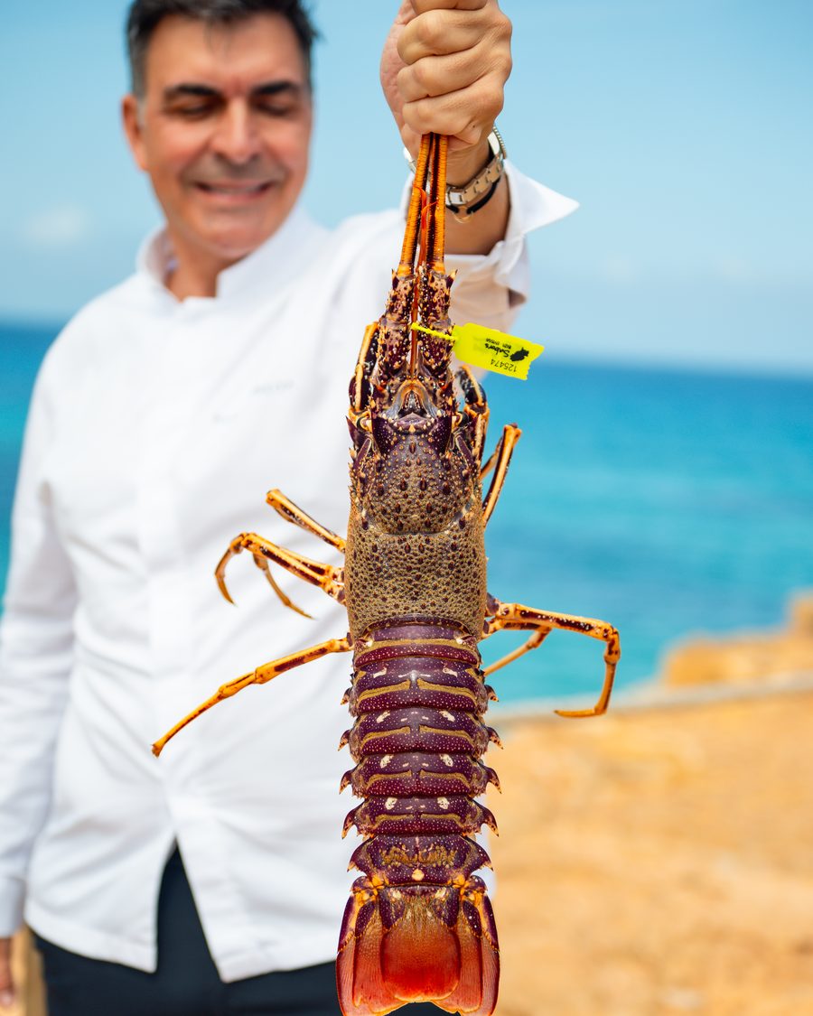 Ramón Freixa sosteniendo una langosta frente al mar